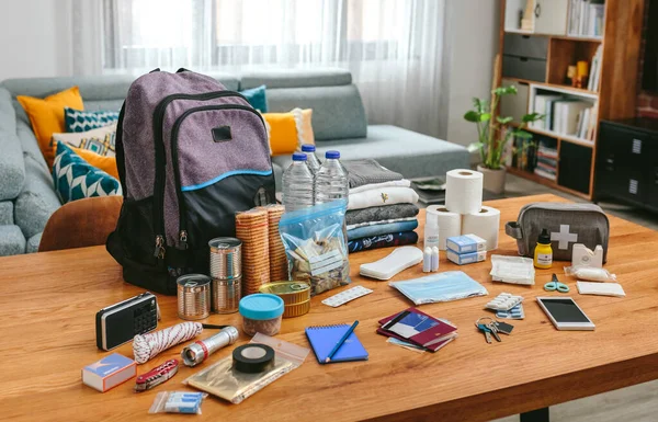 Equipo de mochila de emergencia organizado sobre la mesa —  Fotos de Stock