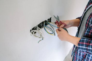 Elektrikçi bir evin elektrik tesisatı üzerinde çalışıyor.