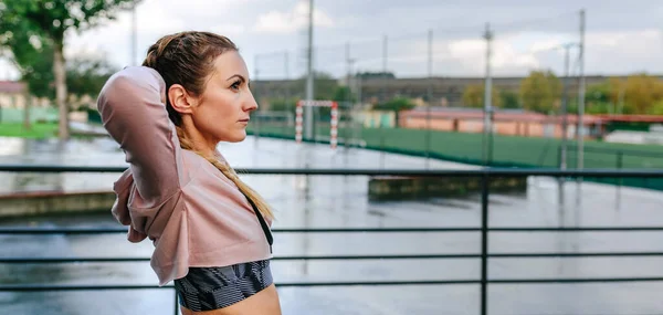 Sportvrouw stretching nek en schouders buiten — Stockfoto