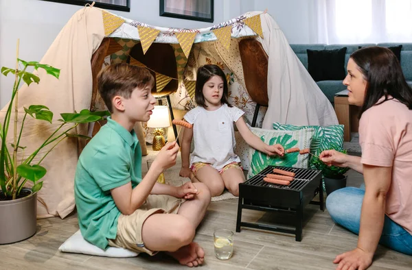 Famiglia grigliate e mangiare salsicce sul barbecue — Foto Stock