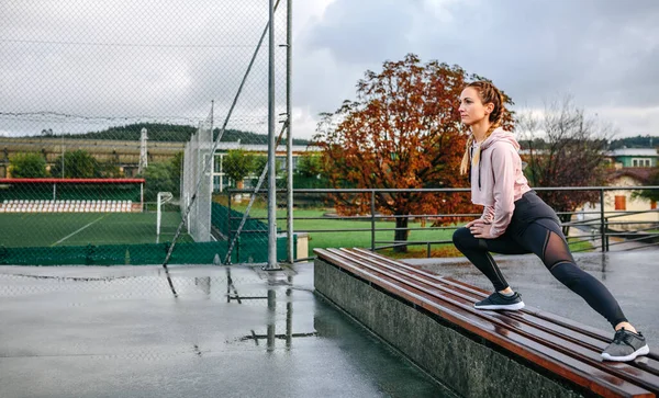 Pemuda Olahragawan Merentangkan Kaki Bangku Luar Ruangan — Stok Foto