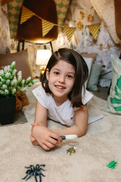 Chica jugando con lupa y errores de juguete — Foto de Stock