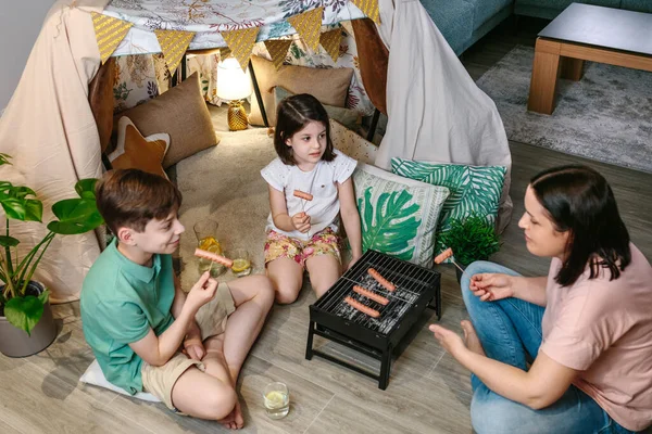 Vista dall'alto della famiglia grigliate e mangiare salsicce sul barbecue — Foto Stock