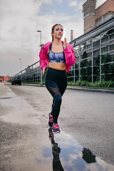 Mujer corriendo en una zona industrial — Foto de Stock