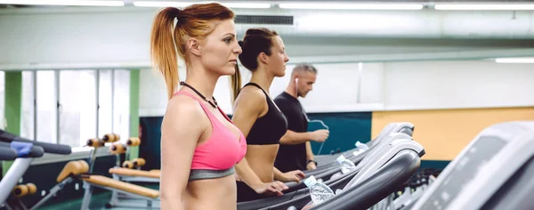 Mensen trainen over loopbanden op fitnesscentrum — Stockfoto