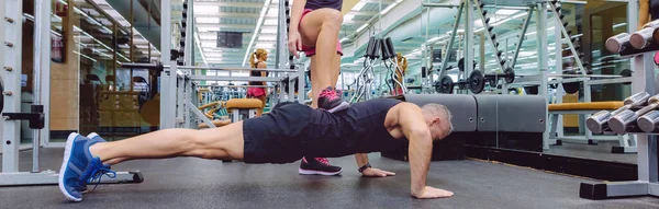 Woman coach training a man with hard push ups — Stock Photo, Image