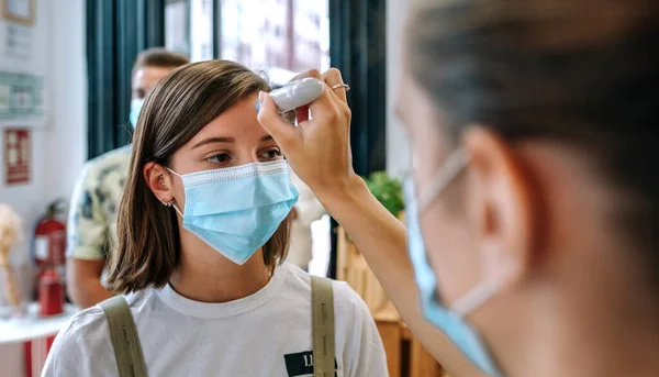 Geschäftsinhaber überprüft Kunden auf Fieber — Stockfoto