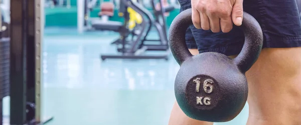 Man holding kettlebell in the gym — Stock Photo, Image