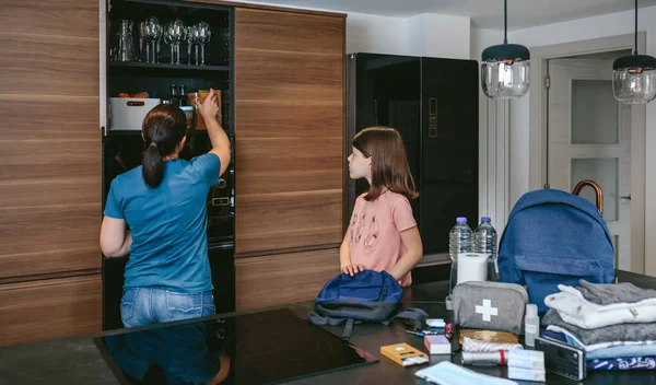 Madre preparando mochila de emergencia con su hija — Foto de Stock