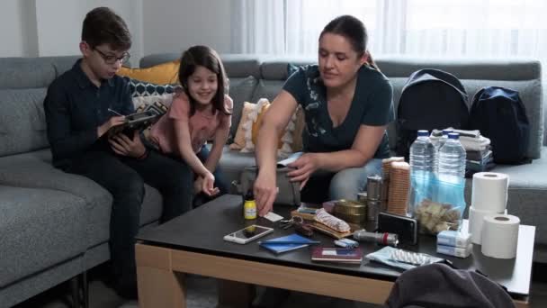 Madre preparando mochila de emergencia con sus hijos — Vídeos de Stock