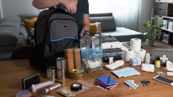 Mujer poniendo comida para preparar mochila de emergencia — Vídeos de Stock