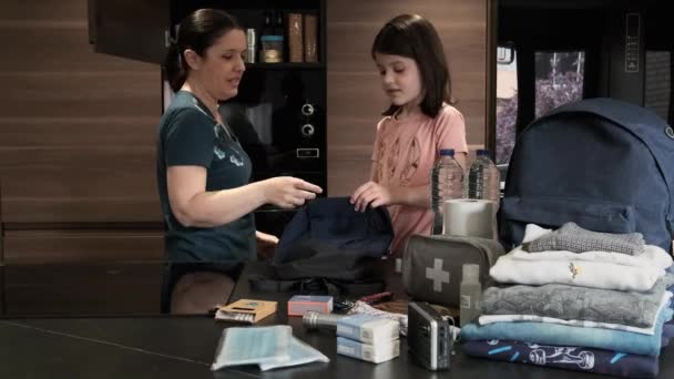 Мати готує екстрений рюкзак зі своєю дочкою — стокове відео