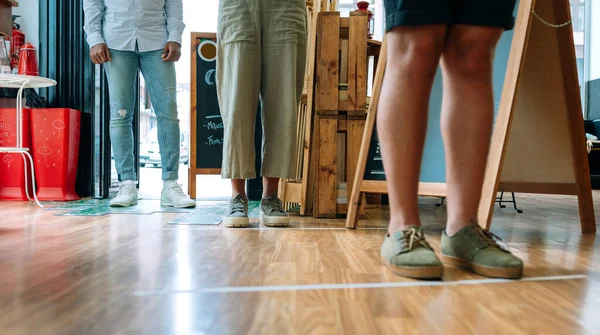 Personas irreconocibles haciendo cola para mantener la distancia social — Foto de Stock