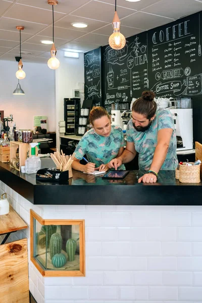 Propietarios de una cafetería trabajando mirando la tableta — Foto de Stock