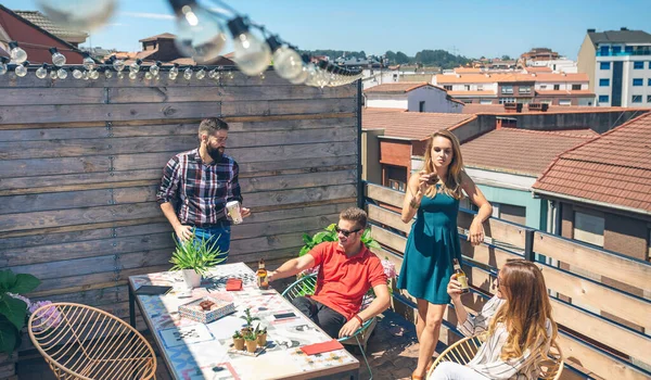 Amigos hablando y bebiendo en una fiesta en una terraza — Foto de Stock