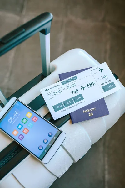 Maleta con billete de avión, pasaporte y teléfono celular — Foto de Stock