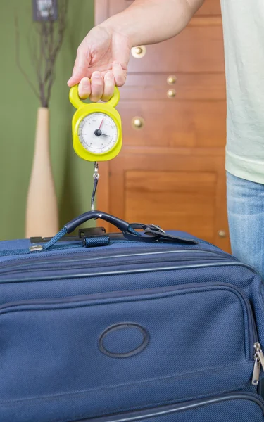 Mulher verificando o peso da bagagem com um equilíbrio de mão — Fotografia de Stock