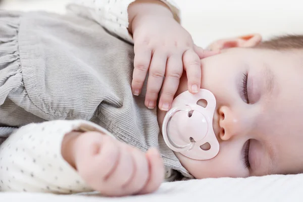Beyaz Baldakenli üzerinde uyuyan sevimli bebek kız — Stok fotoğraf