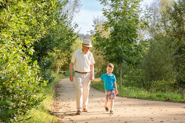 Grandfather and grandchild walking outdoors — Stock Photo, Image