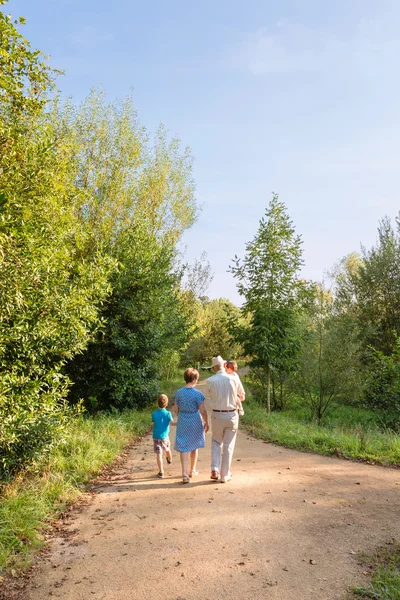 Großeltern und Enkel spazieren im Freien — Stockfoto