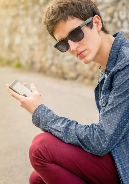 Nastolatek z okulary za pomocą smartfona — Zdjęcie stockowe