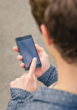 açık havada bir akıllı telefon kullanan yenilikçi genç