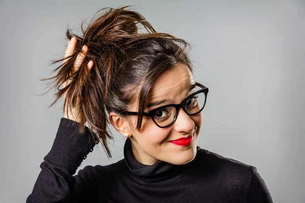 Real girl with glasses and red lips touching her hair bun — Stock Photo, Image