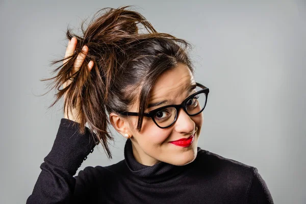 Real girl with glasses and red lips touching her hair bun Royalty Free Stock Images