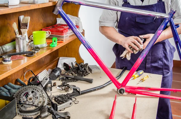 Hands of real bicycle mechanic cleaning frame bike — Stock Photo, Image