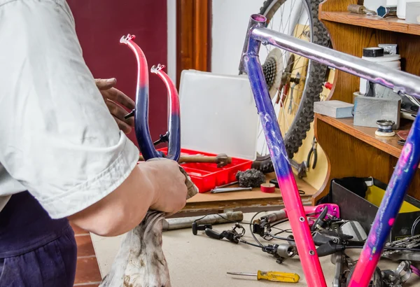 Hands of real bicycle mechanic cleaning frame bike — Stock Photo, Image