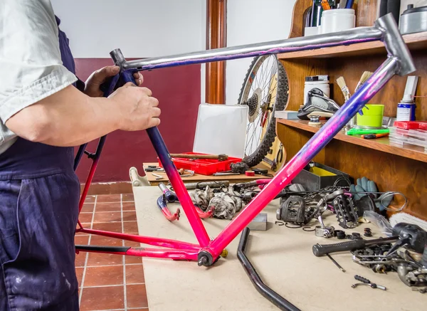 Hands of real bicycle mechanic cleaning frame bike — Stock Photo, Image