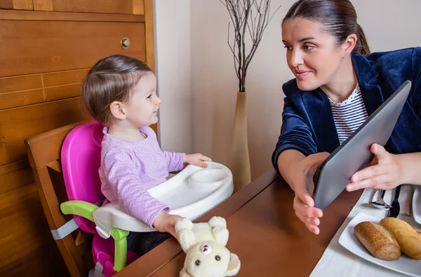 Zakenvrouw moeder en babymeisje op zoek tablet — Stockfoto