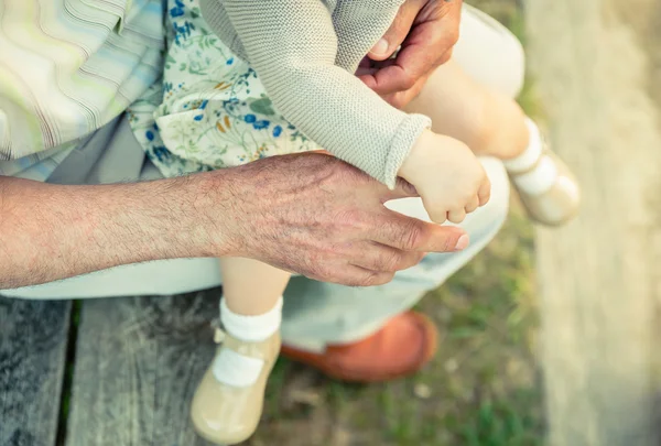 年配の男性の手の指を握り女の赤ちゃん — ストック写真