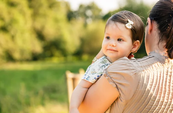 Back view of mother holding baby girl in her arms — Stock Photo, Image