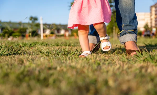 草公園の上を歩くことを学ぶ女の赤ちゃん — ストック写真