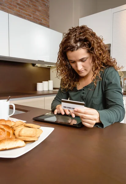Женщина с электронным планшетом рассматривает выплаты по кредитным картам — стоковое фото