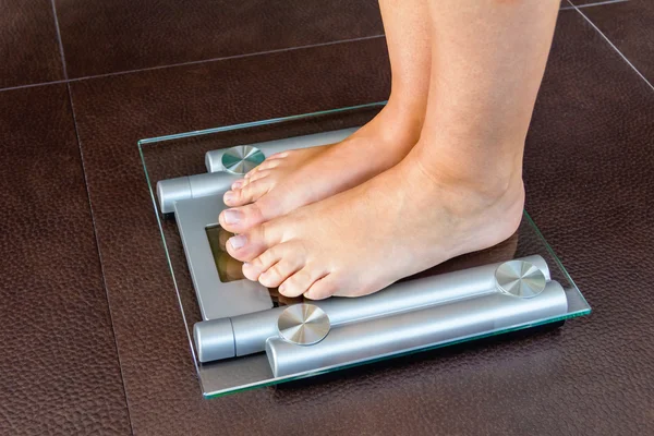 Zbliżenie stóp kobieta stojąc na waga łazienkowa — Zdjęcie stockowe
