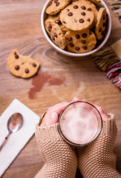 Female hands with hot drink and chocolate cookies — Stock Photo, Image