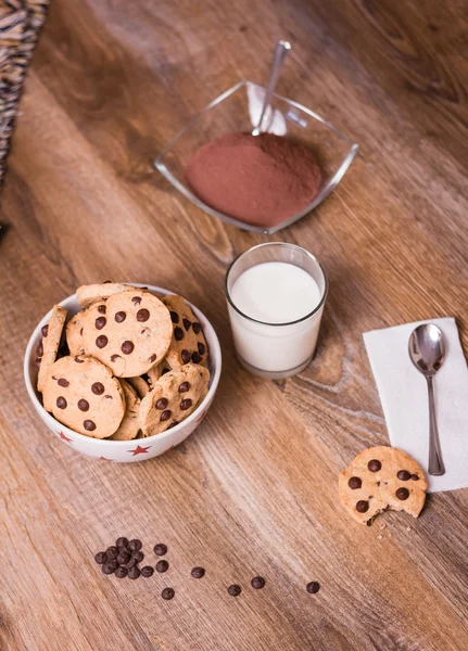 Chocolate chip cookies and milk on wood background — Stock Photo, Image