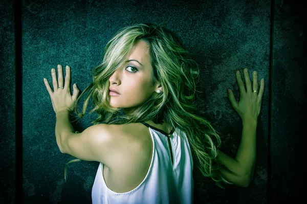 Young woman scared with her hands over a metallic door — Stock Photo, Image