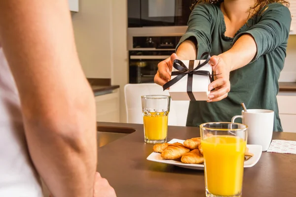 Femme mains donnant une boîte cadeau à son petit ami — Photo