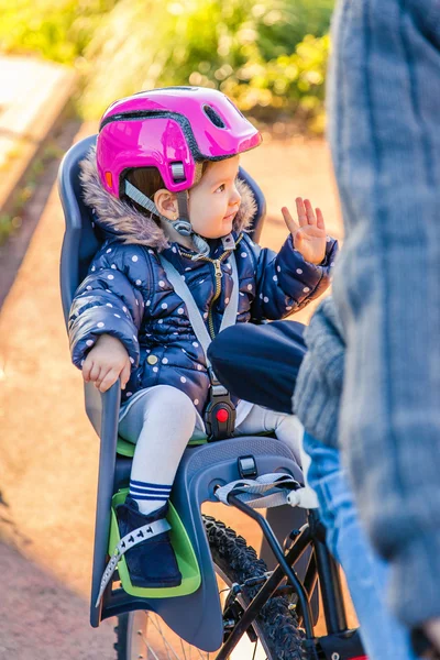 Little girl with helmet on head sitting in bike seat — Stock Photo, Image