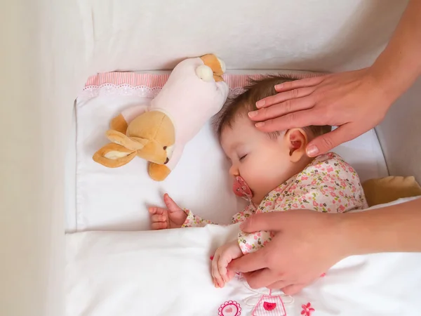 Uyuyan bebek kızı okşama annenin elleri — Stok fotoğraf