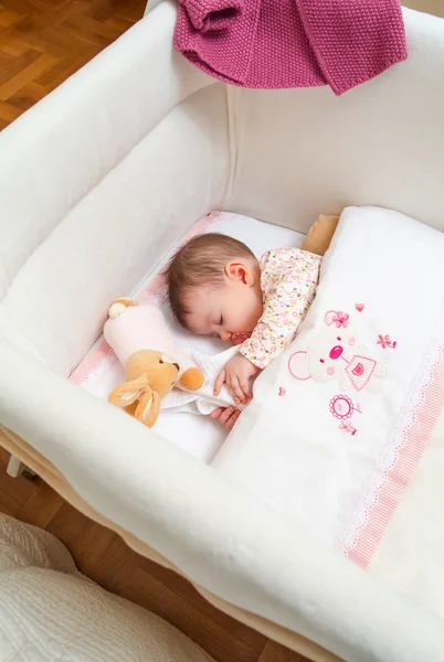 Baby girl sleeping in a cot with pacifier and toy — Stock Photo, Image