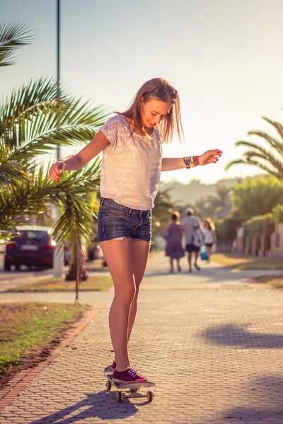 Menina jovem montando em um skate ao ar livre no verão — Fotografia de Stock