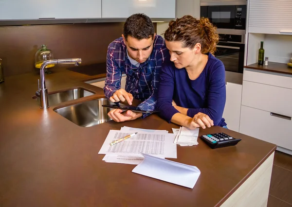 Casal revisando suas contas com um tablet digital — Fotografia de Stock