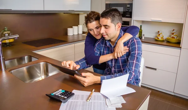 Pareja alegre usando tableta digital en casa de la cocina —  Fotos de Stock