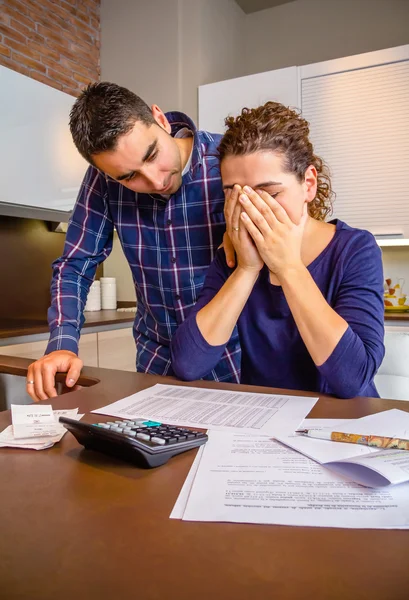 Verzweifelte junge Frau mit Schulden bei der Überprüfung der Rechnungen — Stockfoto