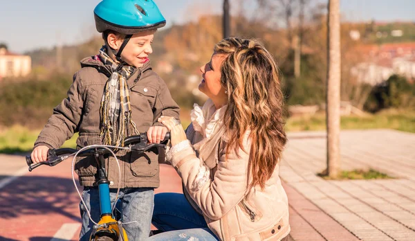 Jeune femme avec enfant sur vélo le jour ensoleillé — Photo