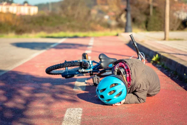 Chico tocándose la cabeza después de caerse en bicicleta — Foto de Stock